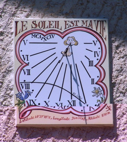 Cadran solaire à Risoul, 50x60 cm, style polaire, façade sud-est. Composition traditionnelle avec encadrement, devise, date et dooraonnées du lieu. Une courbe anniversaire (26 juillet) personnalise cette fenêtre sur le temps. Cadran solaire à Risoul, 1994